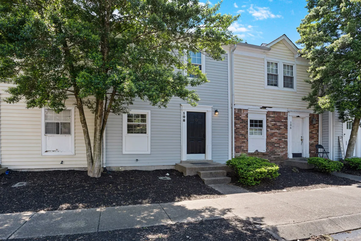 This exterior image shows the front door of Green Retreat surrounded by inviting landscaping and large windows. The setting suggests a welcoming environment and opportunities for guests to relax on the porch or take neighborhood walks, which is ideal for business travelers wishing to unwind after a long day.